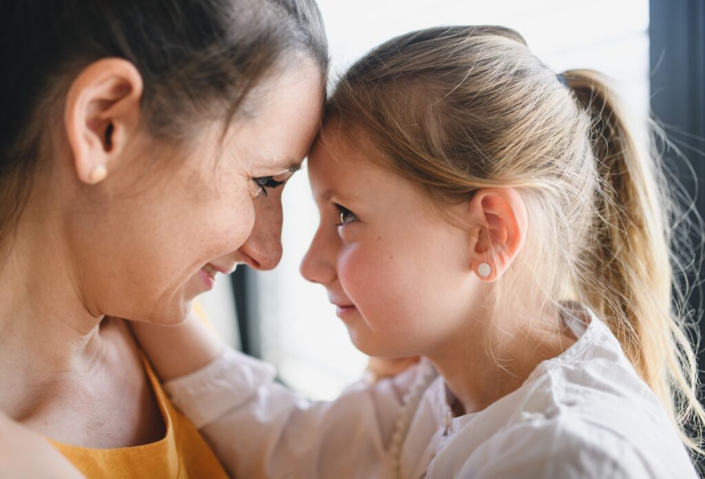 Mother and child indoors at home, hugging