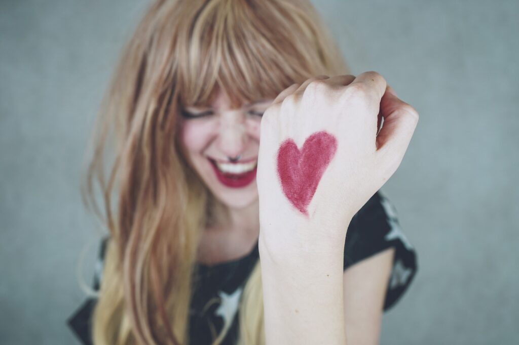 Strong woman with a red heart drawing in her hand