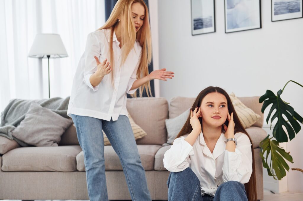 In bad mood. Young mother with her daughter is at home at daytime